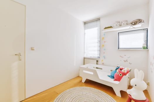 a child's room with white walls and wooden flooring the room is decorated in paste pink, blue and green tones