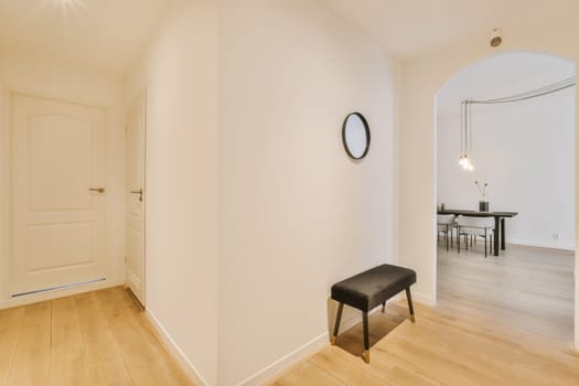 an empty living room with wood flooring and white walls there is a mirror on the wall in the corner