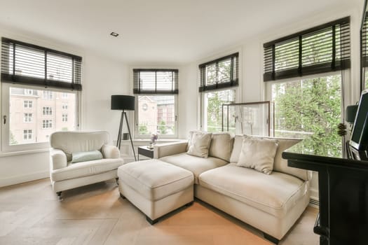 a living room with two couches and a tv on the wall in front of the window looking out onto the street