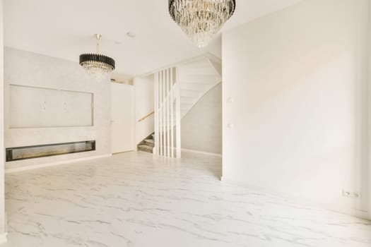 an empty living room with marble flooring and chandels hanging from the ceiling to the wall is white