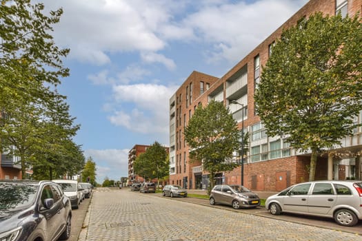 a city street with cars parked on the side and buildings in the back ground, all lined up to the right