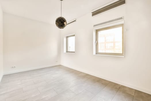an empty room with white walls and wood flooring, there is a large window that looks out onto the street