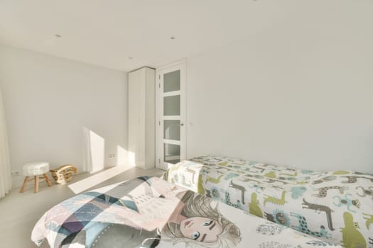 a bed in a room with white walls and wood flooring on the right side, there is an open door that leads to another room
