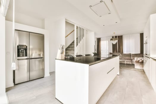 a modern kitchen with white cabinets and black countertops on the island in an open plan living room is also visible