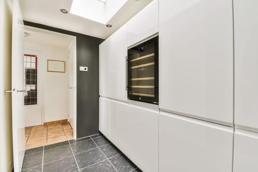 a modern kitchen with white cabinets and black countertops on the wall, in an open plan space for cooking