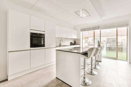 a modern kitchen with white cabinets and appliances in the middle part of the room that is open to the patio