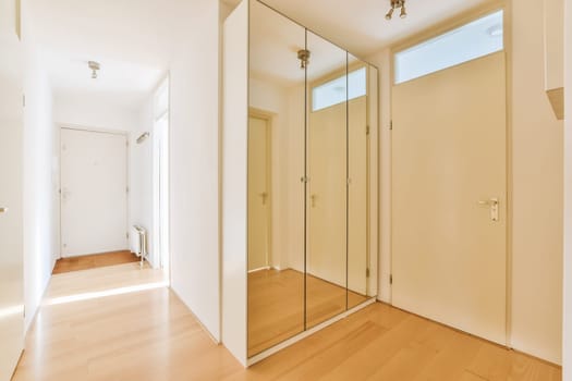 an empty room with wood flooring and glass partitions on the walls, there is a large mirror in the wall