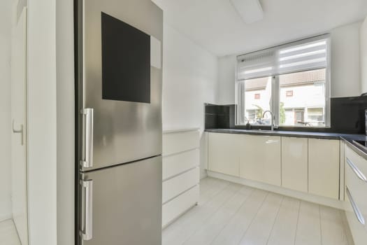 a modern kitchen with white cabinets and black counter tops on the island in this photo is taken from the inside