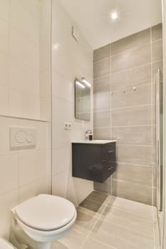 a bathroom with a white toilet and shower stall in the corner next to it is a mirror on the wall
