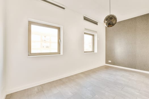 an empty room with white walls and wood flooring, there is a large window in the wall has no light