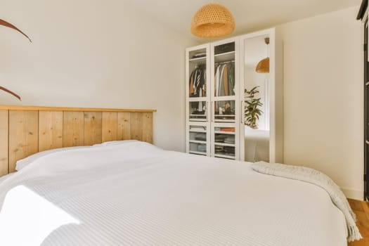a bedroom with white bedding and wooden headboards in the room is lit by natural light from the window