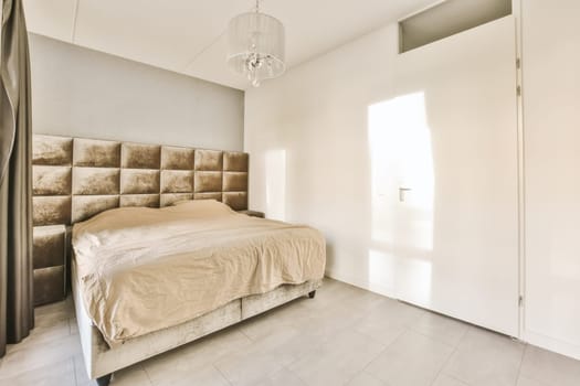 a bedroom with a bed and a chandel on the wall in front of the bed is an open door