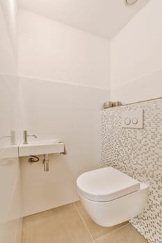 a bathroom with white tiles on the wall and toilet in the corner, there is a sink next to it