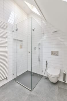 a modern bathroom with white tile walls and flooring, including a glass walk - in shower stall on the right side