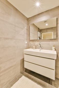 a bathroom with a sink, mirror and toilet paper on the wall next to it is a white bath mat
