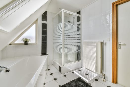 a white bathroom with black and white tiles on the floor, there is a freestanding shower stall in the corner