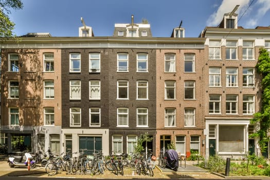 some bikes parked on the side of the street in front of an apartment building with many windows and bals