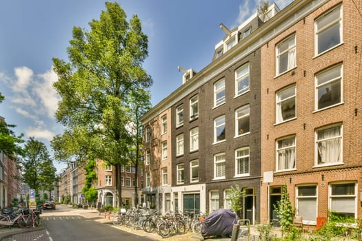 a city street with bikes parked on the sidewalks and buildings in the background, there is a blue sky