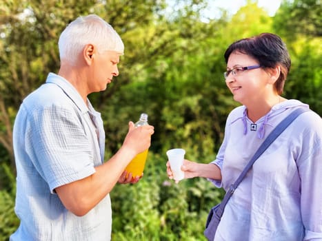 Friends are sharing drinks and laughter in a lush green environment, basking in the warmth of a sunny afternoon.