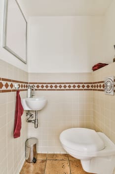 a white toilet in a small bathroom with tiled walls and brown tile on the floor, there is a mirror above it