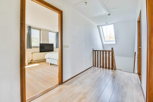 an empty room with wood flooring and large mirror on the wall in front of the door to the living room