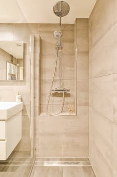 a bathroom with a shower head and hand held in front of the wall, next to a sink that is on the right side