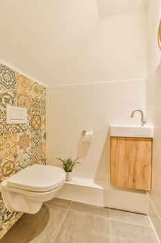a bathroom with an artistic design on the wallpaper and toilet in the room is white, beige and orange