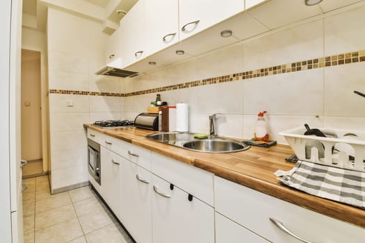 a kitchen with white cabinets and wood counter tops in the center of the image is an open door leading to another room
