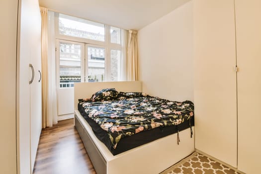 a bedroom with a bed and wardrobes in the corner, there is an open door leading to another room