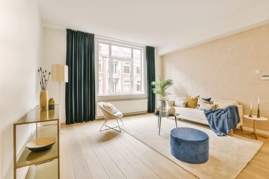 a living room with wood flooring and white walls, including a large window that looks out onto the street