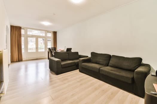 a living room with two couches and a coffee table in the center of the room is white painted walls