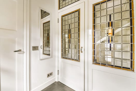 the inside of a house with white doors and glass window panes on either side by side to each other windows