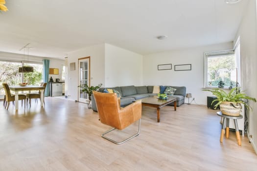 a living room with wood flooring and white walls in the center of the room is a dining table, two chairs and a