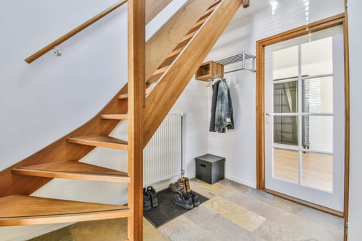 a wooden staircase in a room with white walls and wood steps leading up to the second floor there is a mirror on the wall