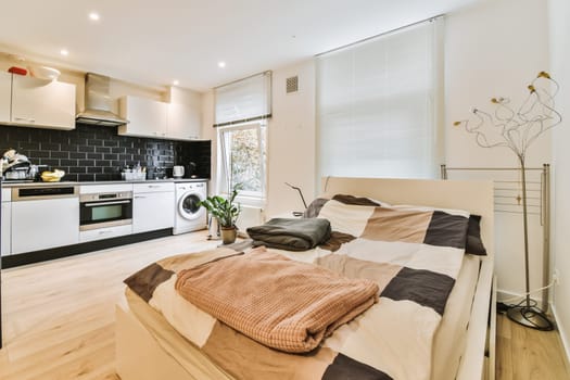 a bedroom with a bed, microwave and oven in the corner next to each other room's kitchen area
