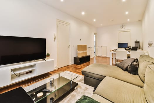 a living room with couch, tv and coffee table in the photo is taken to the right side of the room