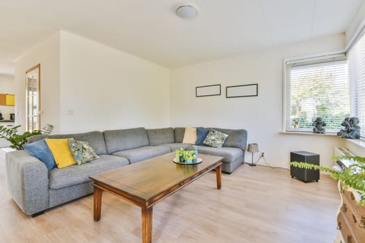 a living room with a couch and coffee table in front of the window looking out to the garden outside on a sunny day