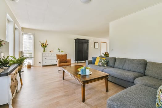 a living room with couches, coffee table and television set in the center of the room is white walls