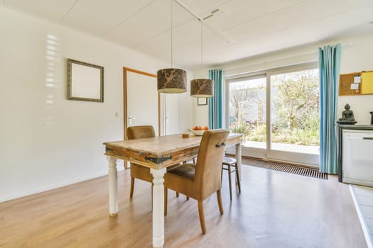 a dining room with wood flooring and white walls, an open door leading to the patio area is visible on the right side