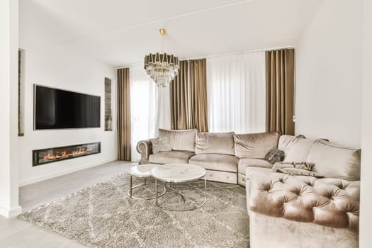 a living room with two couches and a fire place in the center of the room, there is a tv on the wall