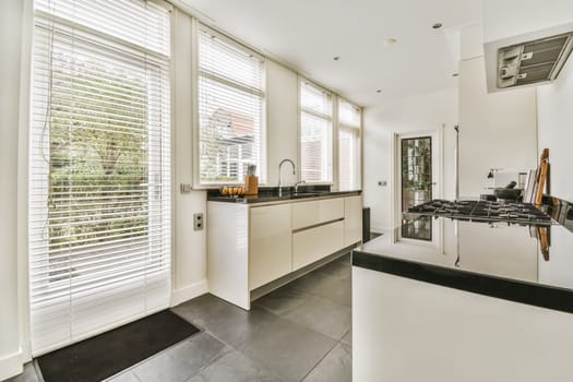 a modern kitchen with black counter tops and white shutters on the windows in the photo is taken from outside