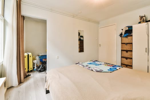 a bedroom with a bed, closet and clothes hanging on the wall in front of the door to the room