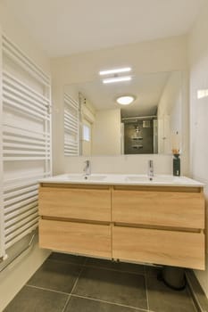 a modern bathroom with wood cabinets and white tiles on the floor, along with a large mirror over the sink