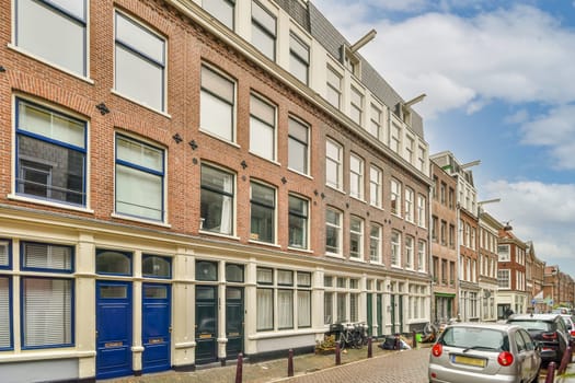 a city street with cars parked on the side and people walking down the street in front of buildings, all facing to one another