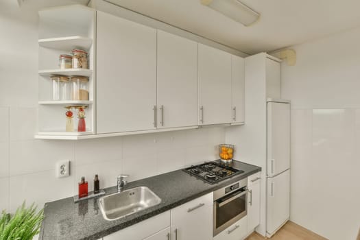 a kitchen with white cabinets and black granite counter tops in the center of the image is an oven, dishwasher, sink
