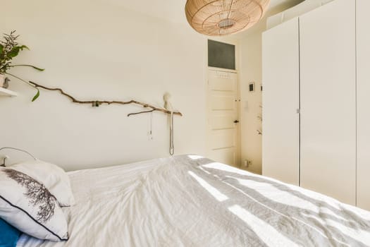 a bedroom with a bed and some plants on the headboards hanging from a ceiling light over the bed
