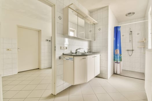 a bathroom with white tile and blue shower curtain on the window simng it's in front of the sink