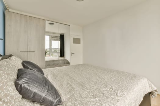 a bedroom with a bed and mirror on the wall next to each other room's closets in it