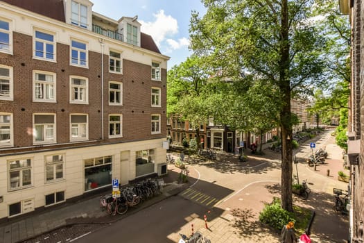 a city street with buildings and bicycles parked on the sidewalk in front of an apartment building, taken from above