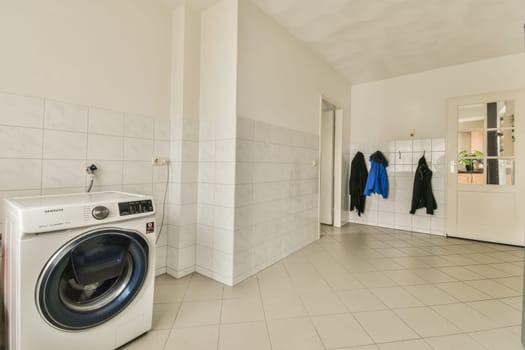 a laundry room with a washer, dryer and clothes hanging on the wall next to the washing machine